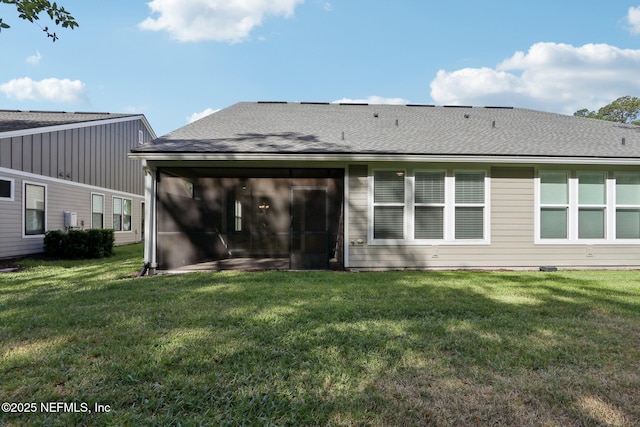 rear view of property with a lawn, a sunroom, and roof with shingles