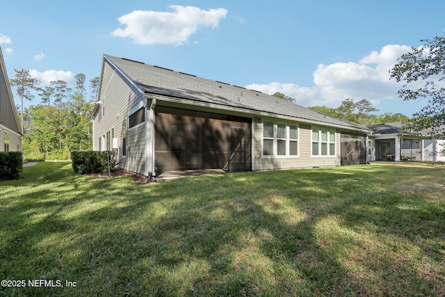 rear view of property with a lawn and a shingled roof