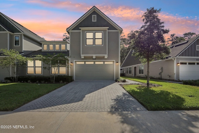 traditional-style house featuring a yard, an attached garage, and driveway