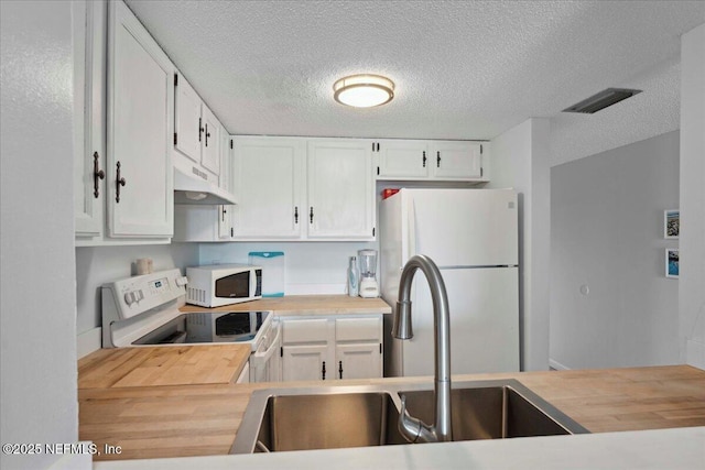 kitchen featuring a sink, wood counters, under cabinet range hood, and white appliances