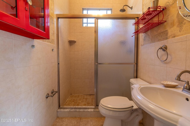 703 Emmett St, Palatka, FL 32177 - full bath featuring tile patterned flooring, a shower stall, tile walls, toilet, and a sink