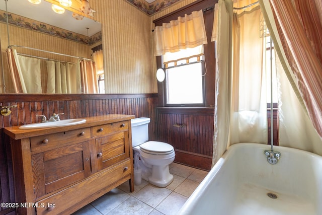 703 Emmett St, Palatka, FL 32177 - full bath featuring vanity, a bath, toilet, wainscoting, and wallpapered walls