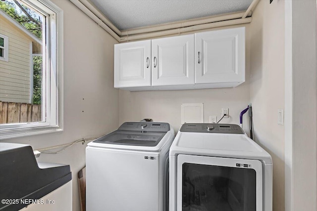 washroom with cabinet space and washer and dryer