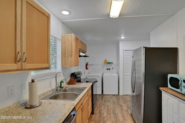 237 Riberia St, Saint Augustine, FL 32084 - kitchen featuring independent washer and dryer, appliances with stainless steel finishes, a sink, light wood-style flooring, and under cabinet range hood