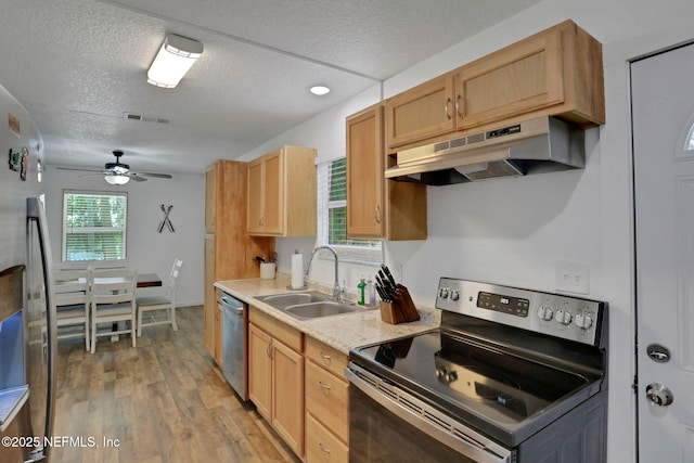 237 Riberia St, Saint Augustine, FL 32084 - kitchen with a sink, a textured ceiling, under cabinet range hood, a ceiling fan, and appliances with stainless steel finishes