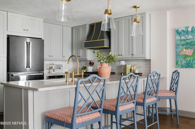 1478 Riverplace Blvd Unit 1008, Jacksonville, FL 32207 - kitchen with range hood, high end refrigerator, tasteful backsplash, light countertops, and a textured ceiling