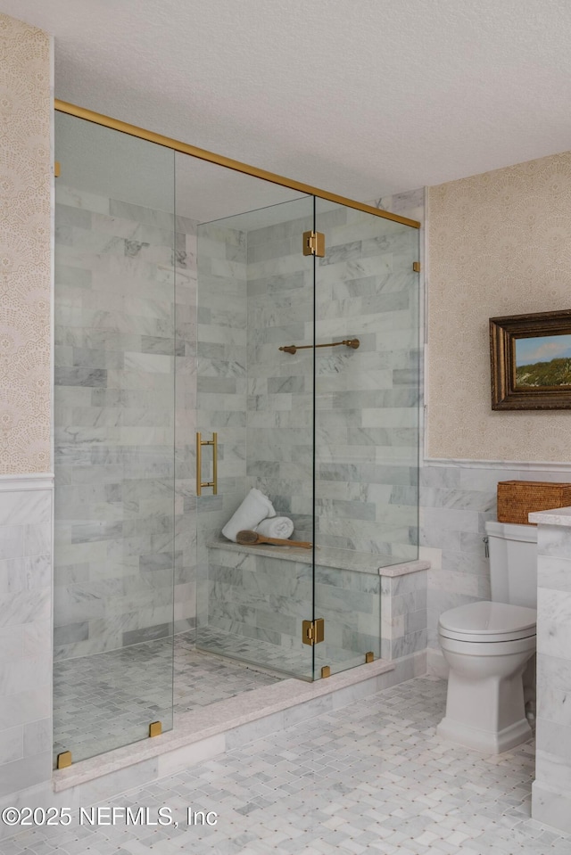 1478 Riverplace Blvd Unit 1008, Jacksonville, FL 32207 - bathroom with tile walls, a stall shower, a wainscoted wall, and a textured ceiling