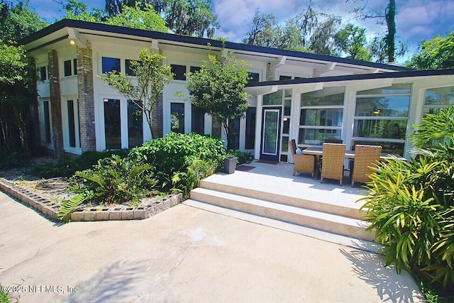 doorway to property with outdoor dining space and a patio area