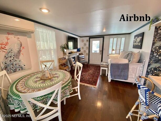 dining area featuring dark wood-style floors and an AC wall unit