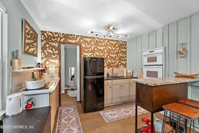 118 Herja Acre Ln, Palatka, FL 32177 - kitchen with freestanding refrigerator, wallpapered walls, a sink, white double oven, and light wood-style flooring