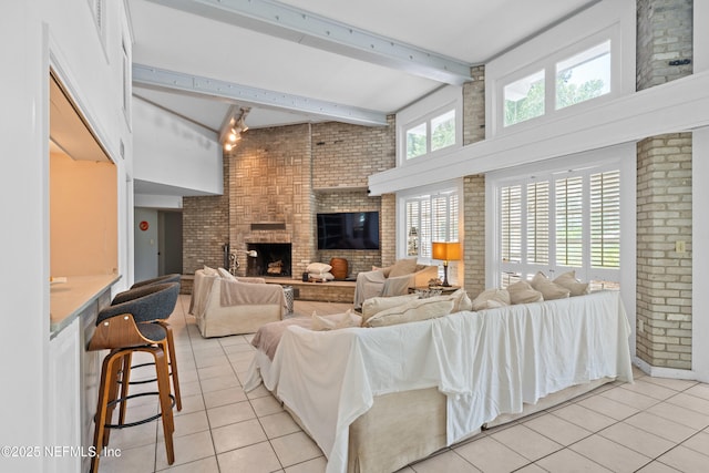 118 Herja Acre Ln, Palatka, FL 32177 - living area featuring brick wall, light tile patterned flooring, a fireplace, beam ceiling, and a high ceiling