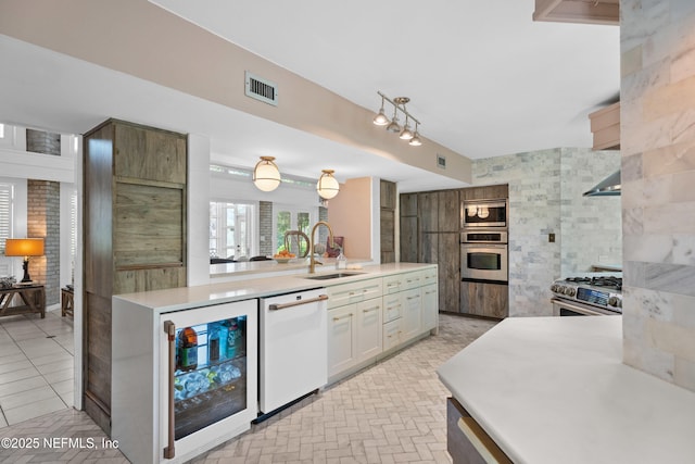 118 Herja Acre Ln, Palatka, FL 32177 - kitchen with stainless steel appliances, wine cooler, a sink, light countertops, and white cabinets