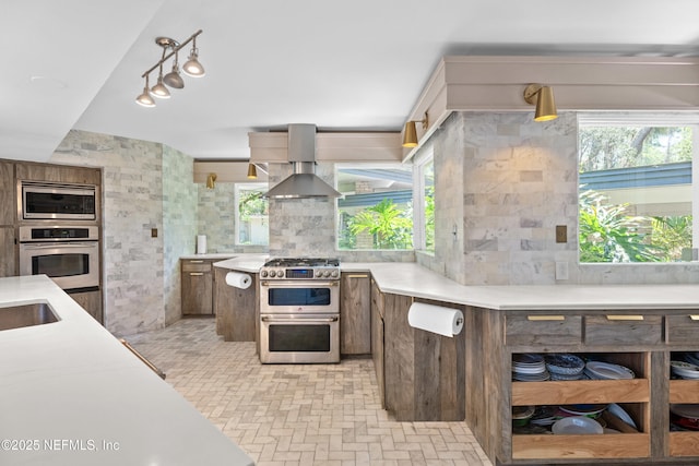 118 Herja Acre Ln, Palatka, FL 32177 - kitchen with appliances with stainless steel finishes, wall chimney range hood, light countertops, brick patterned flooring, and a sink