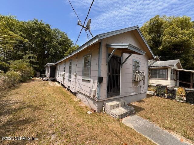 view of side of home with a yard