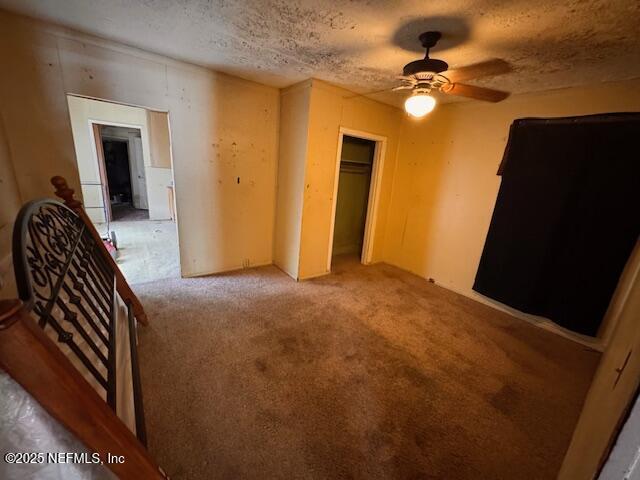 unfurnished bedroom with a textured ceiling, a closet, and carpet