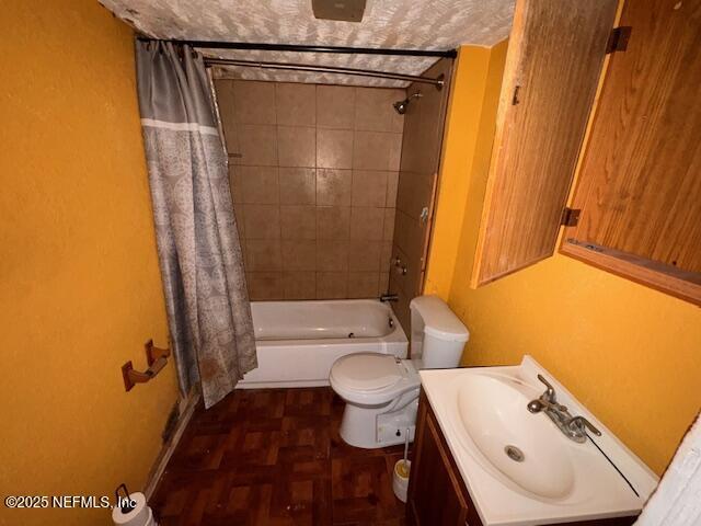 bathroom featuring toilet, shower / bathtub combination with curtain, and vanity