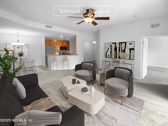 living room with light colored carpet, visible vents, baseboards, and ceiling fan with notable chandelier