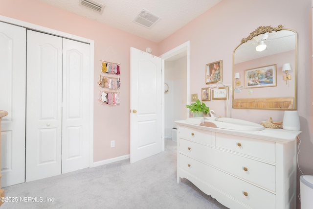 bedroom featuring baseboards, visible vents, a closet, and light colored carpet