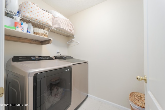 washroom featuring light tile patterned floors, independent washer and dryer, laundry area, and baseboards