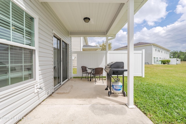 view of patio with fence and a grill