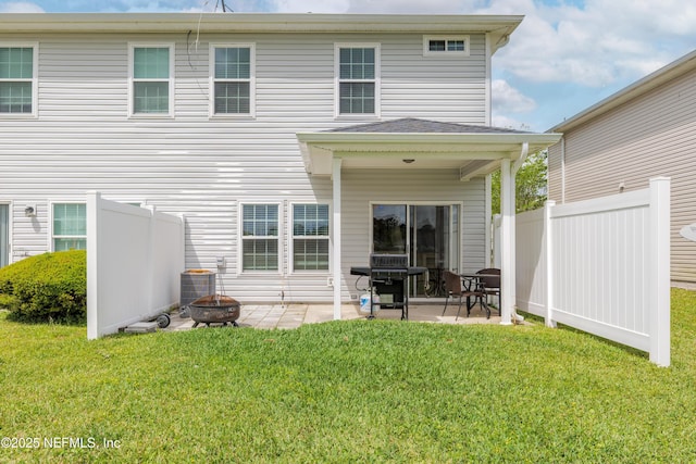 back of house featuring a patio, an outdoor fire pit, cooling unit, a lawn, and fence