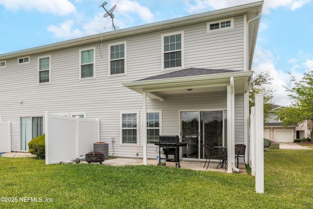 rear view of house with a patio, a yard, central AC, and an outdoor fire pit