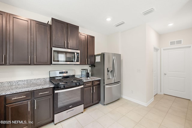 kitchen with appliances with stainless steel finishes, dark brown cabinetry, baseboards, light stone counters, and recessed lighting