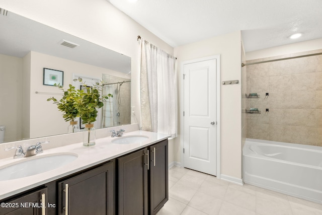 full bath with tile patterned floors, double vanity, baseboards, and shower / tub combination