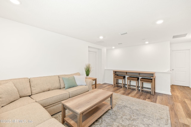 living area featuring wood finished floors and recessed lighting