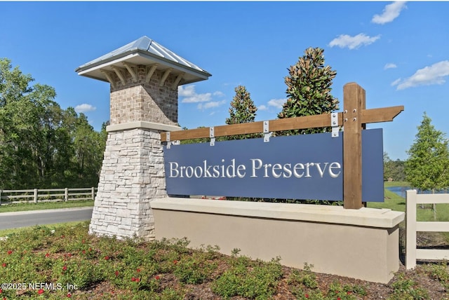 community / neighborhood sign featuring fence