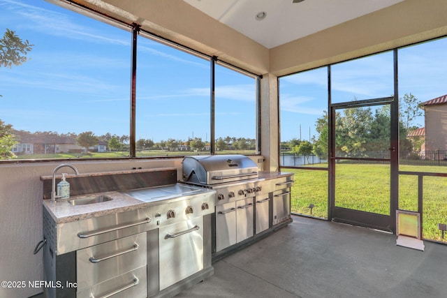 sunroom featuring area for grilling, a sink, and a water view