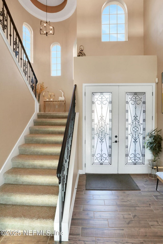 foyer entrance featuring wood finished floors, stairs, and a high ceiling