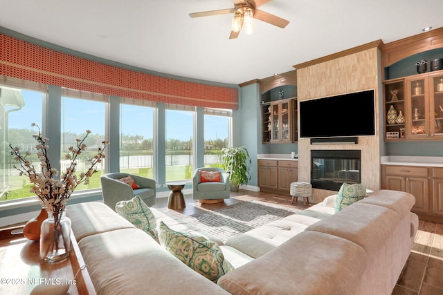 living room with a fireplace, wood finished floors, and a ceiling fan