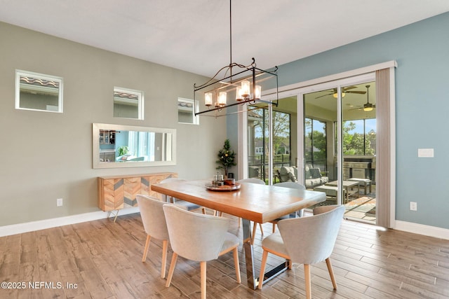 dining space featuring baseboards, ceiling fan with notable chandelier, and light wood-style flooring
