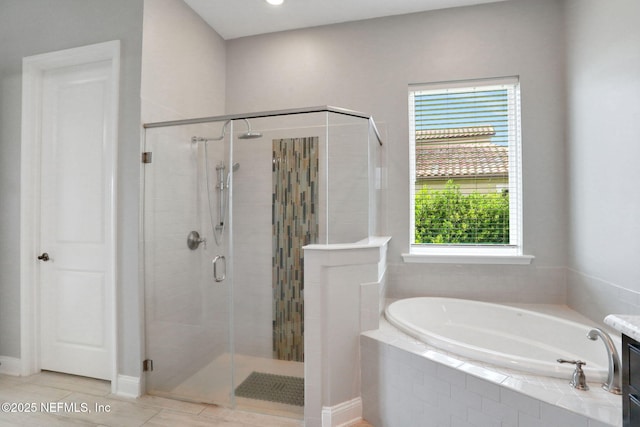 bathroom featuring plenty of natural light, a bath, and a stall shower