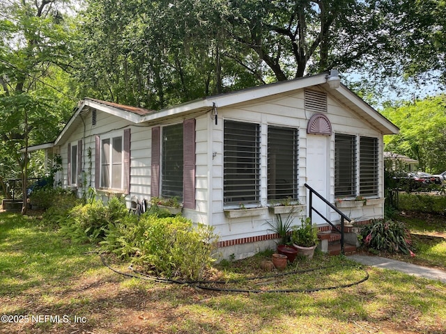 view of side of property with crawl space and entry steps