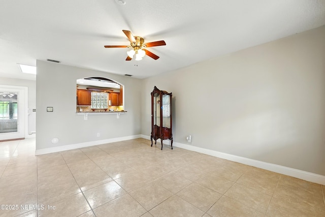 spare room featuring baseboards, ceiling fan, light tile patterned flooring, and visible vents