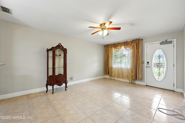 foyer with light tile patterned floors, baseboards, a ceiling fan, and visible vents