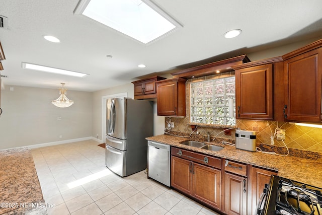 kitchen with baseboards, a sink, appliances with stainless steel finishes, and tasteful backsplash