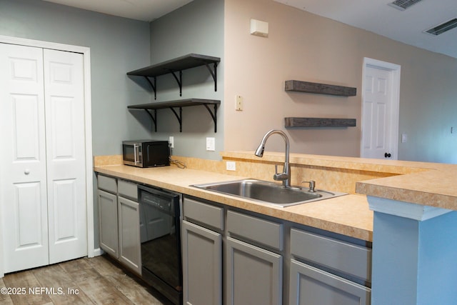 kitchen featuring black dishwasher, open shelves, gray cabinets, and a sink
