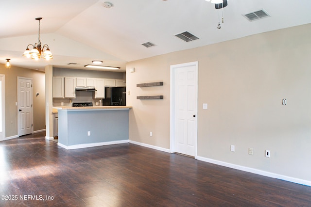 unfurnished living room with visible vents, vaulted ceiling, and dark wood finished floors
