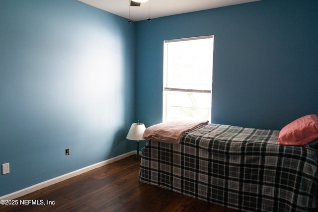 bedroom featuring wood finished floors and baseboards