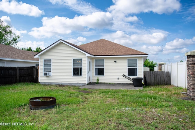 rear view of property featuring a patio, a shingled roof, a yard, a fenced backyard, and cooling unit
