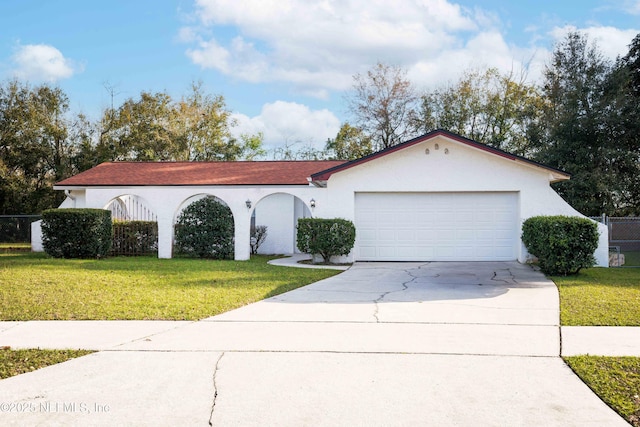 mediterranean / spanish house with driveway, a front yard, and stucco siding