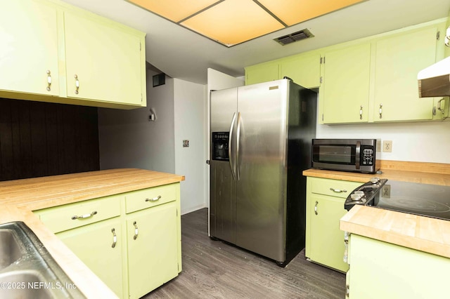 kitchen with wood finished floors, butcher block countertops, stainless steel appliances, extractor fan, and visible vents