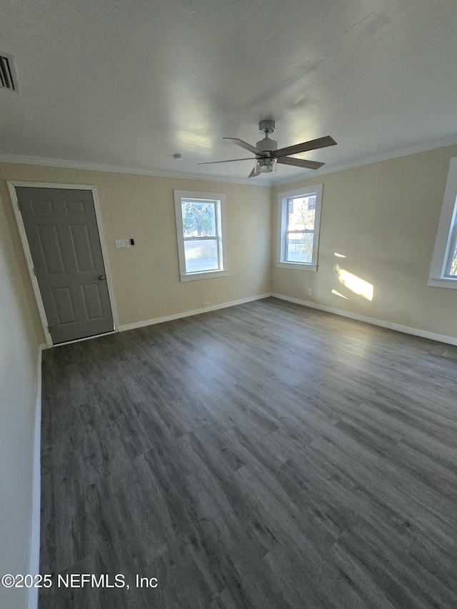 interior space with baseboards, ornamental molding, a ceiling fan, and dark wood-type flooring