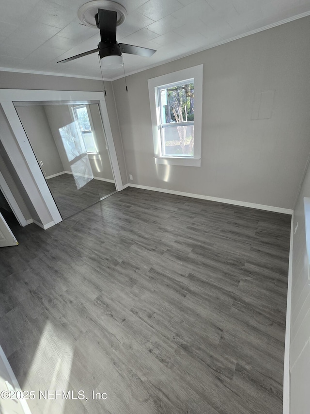 unfurnished bedroom featuring ornamental molding, ceiling fan, wood finished floors, and baseboards