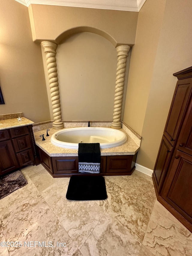 bathroom featuring ornate columns, ornamental molding, and a bath