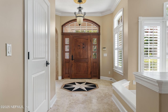 tiled entryway featuring baseboards and ornamental molding