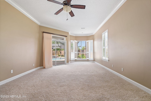 carpeted empty room featuring baseboards, ceiling fan, ornamental molding, and a textured ceiling